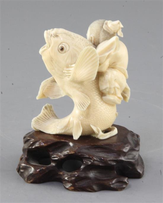 A Japanese ivory group of Kinko riding a carp, Meiji period, height 7.5cm, wood stand